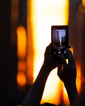 A stunning photograph of Manhattanhenge sunset in New York City captured on a smartphone.