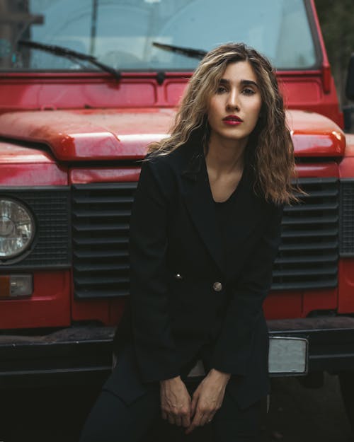 Woman in Black Blazer Standing in front of Red Car