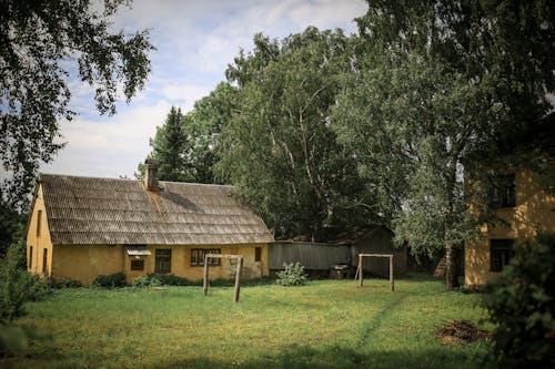 Gratis lagerfoto af bungalow, græsmark, grønne træer