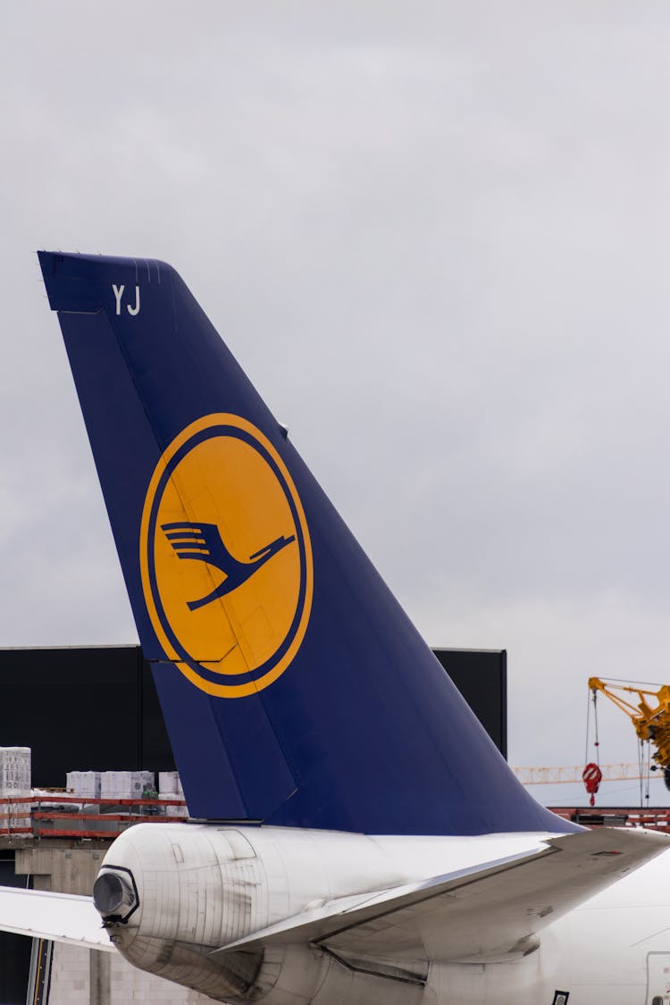 Closeup Of A Navy Blue Airplane Tail With A Yellow Logo