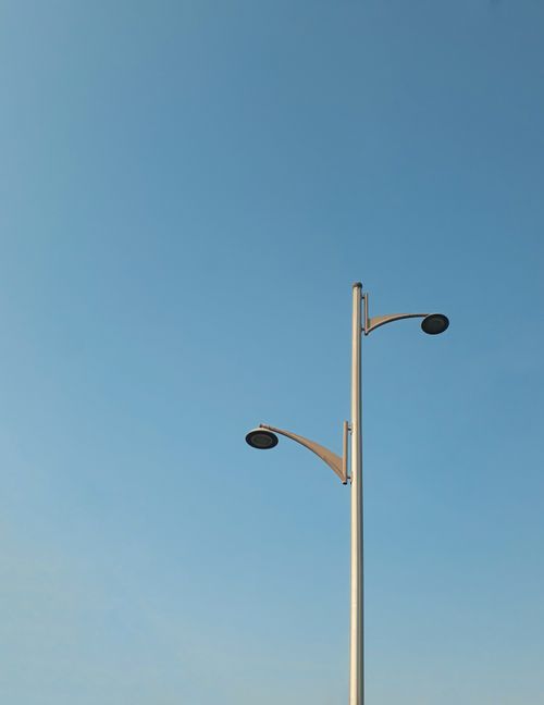 Free Modern streetlight set against a vibrant blue sky, capturing minimalistic urban design in Dubai. Stock Photo
