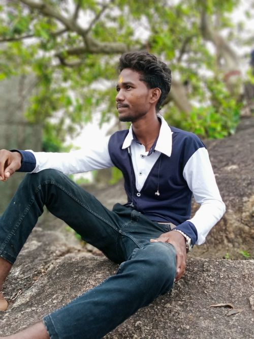 Free Young man sitting on a rock, showcasing fashion in Bilaspur, India. Stock Photo