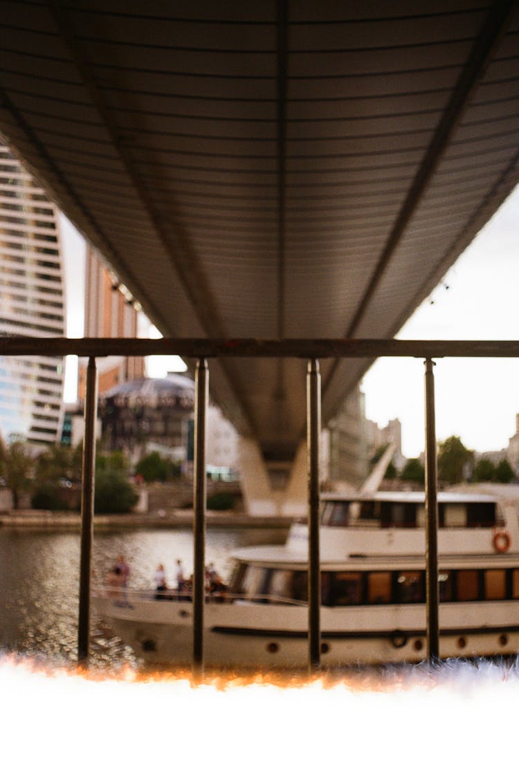 A Boat Passing Under A Bridge