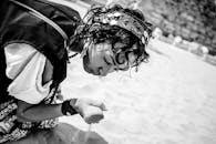 一位身着传统服饰的女子跪在沙漠中，定格了埃及的一瞬