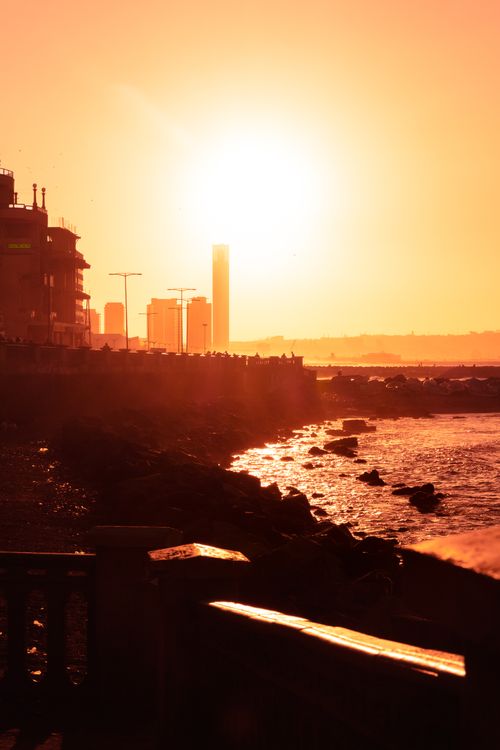 Free Stunning sunset view over the coastline of Algiers, bathing the city in a warm, orange glow. Stock Photo