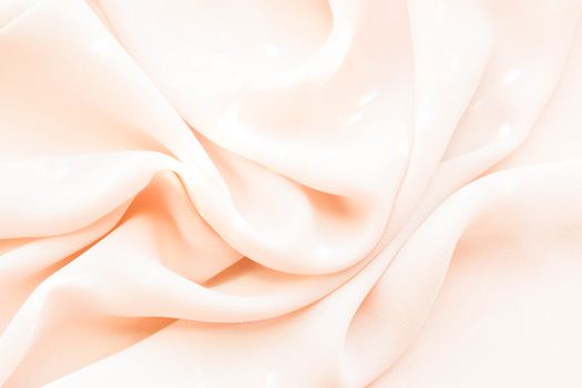 Elegant close-up of smooth cream silk fabric with soft folds and subtle shine, perfect for backgrounds and textile concepts.