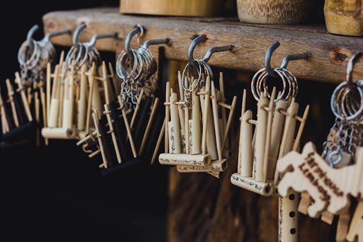 Close-up of handmade bamboo keychains hanging on a rustic shelf.