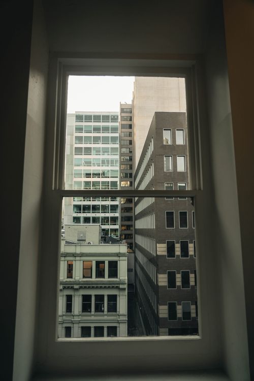 Free View of downtown buildings through a window, capturing urban architecture. Stock Photo