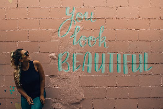 一位时尚女性留着卷发，戴着太阳镜，在多伦多充满活力的壁画旁摆姿势