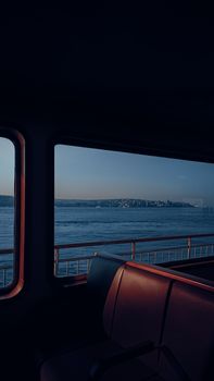 A tranquil view of Istanbul's Bosphorus through a ferry window, capturing the city's charm.
