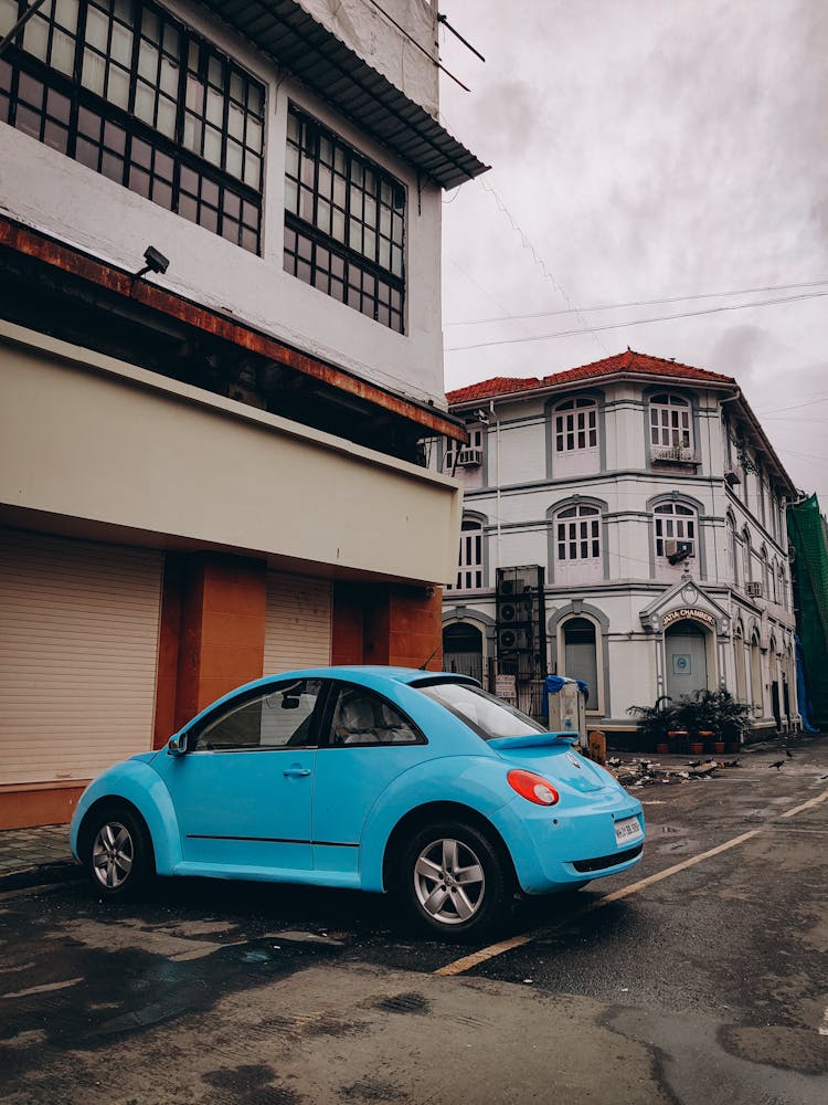 Blue Car Parked In Front Of A Building