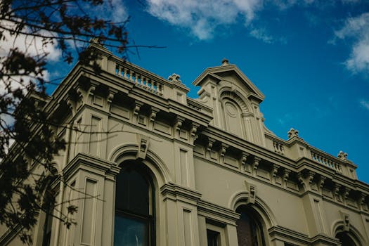 Low angle view of an elegant historic building in Melbourne, showcasing ornate architecture under a blue sky.