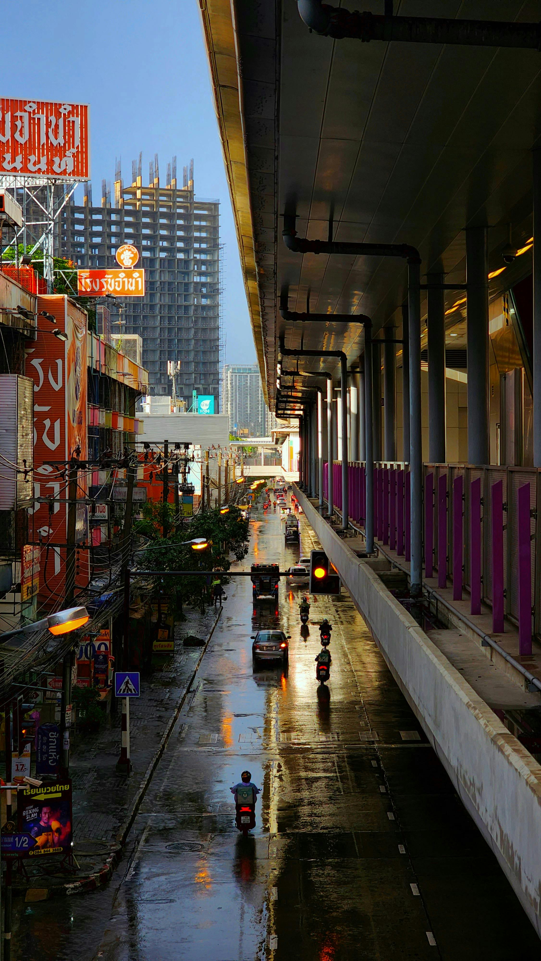 Colorful street in Bangkok showcasing urban life and architecture after rain.