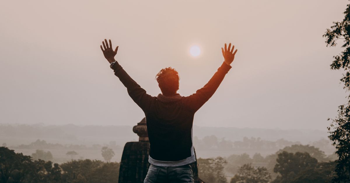person meditating in nature with sunrise, peaceful and hopeful