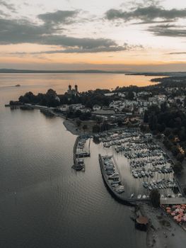 Stunning aerial view of Friedrichshafen harbor on Lake Constance during sunset, capturing serene waters and vibrant skyline.