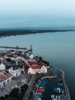 A stunning aerial view of Friedrichshafen with coastline, buildings, and docks at dusk.