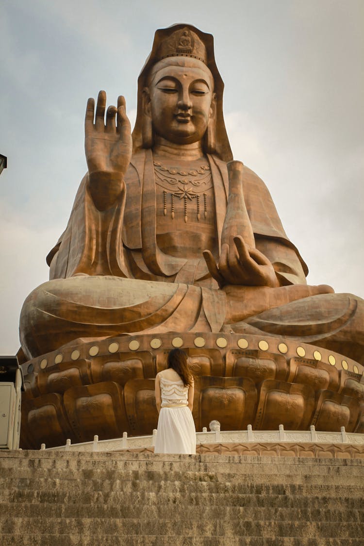 A Woman Standing In Front Of The Giant Monument