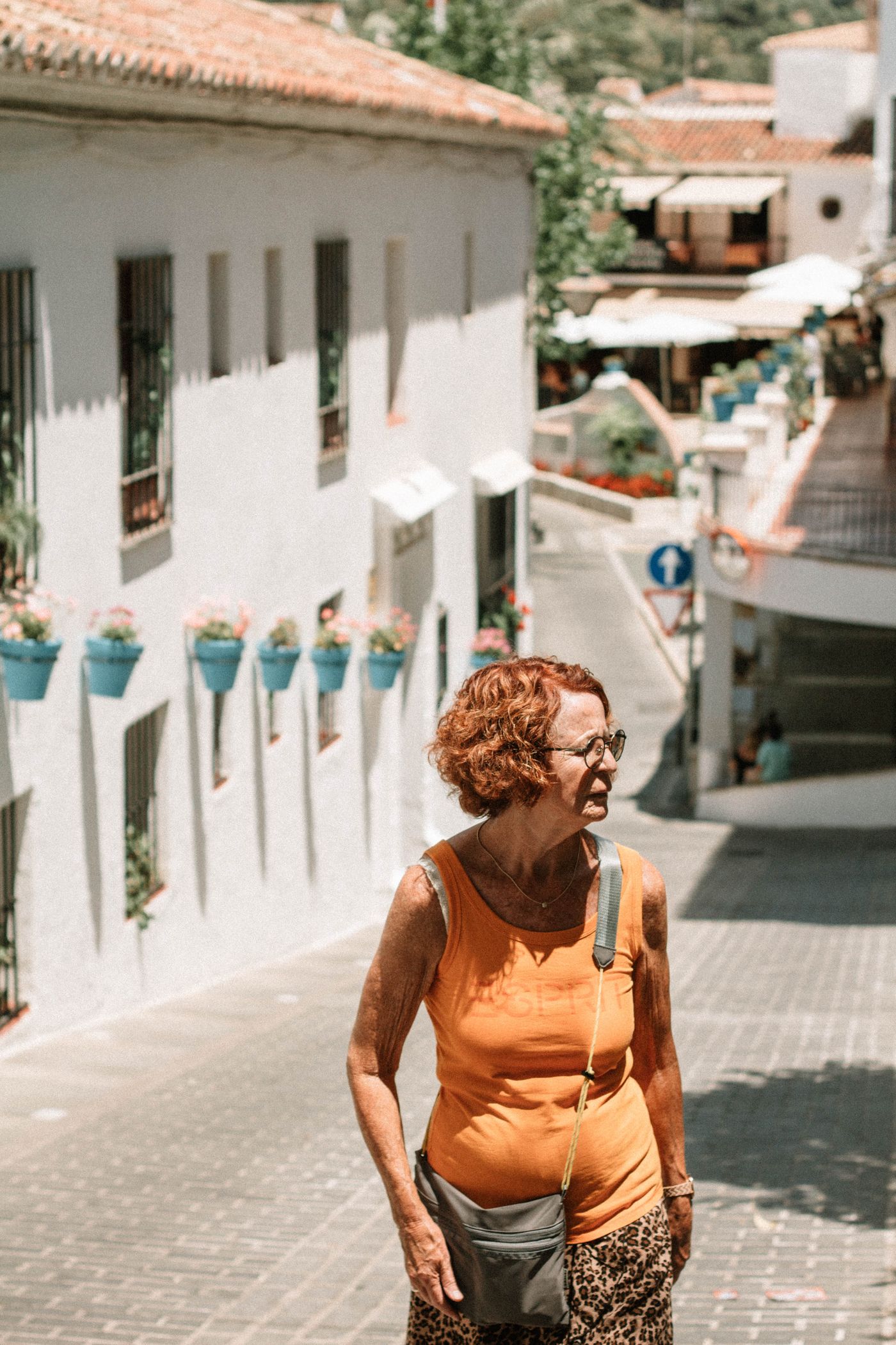 Mujer mayor paseando por una calle mediterránea en España