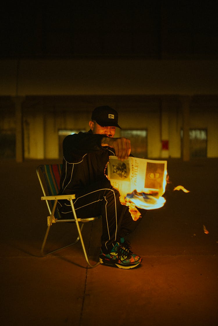 Man Holding Burning Newspaper