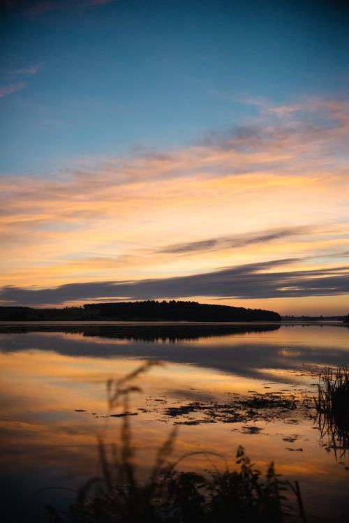 Free Serene sunrise over a calm river in Mogilev, Belarus reflecting vibrant skies and peaceful nature. Stock Photo