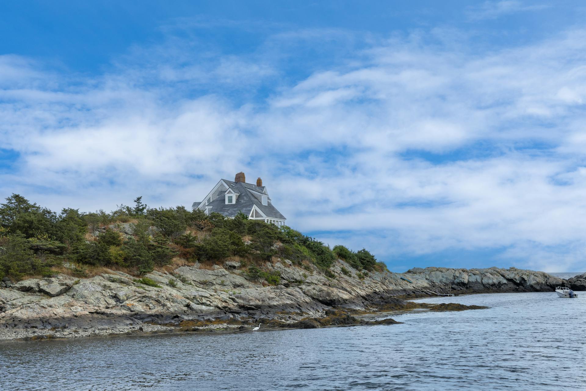 A beautiful coastal house perched on a rocky shoreline in New Shoreham, Rhode Island.