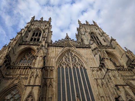 A captivating low angle shot of the historic York Minster with a dramatic sky backdrop.