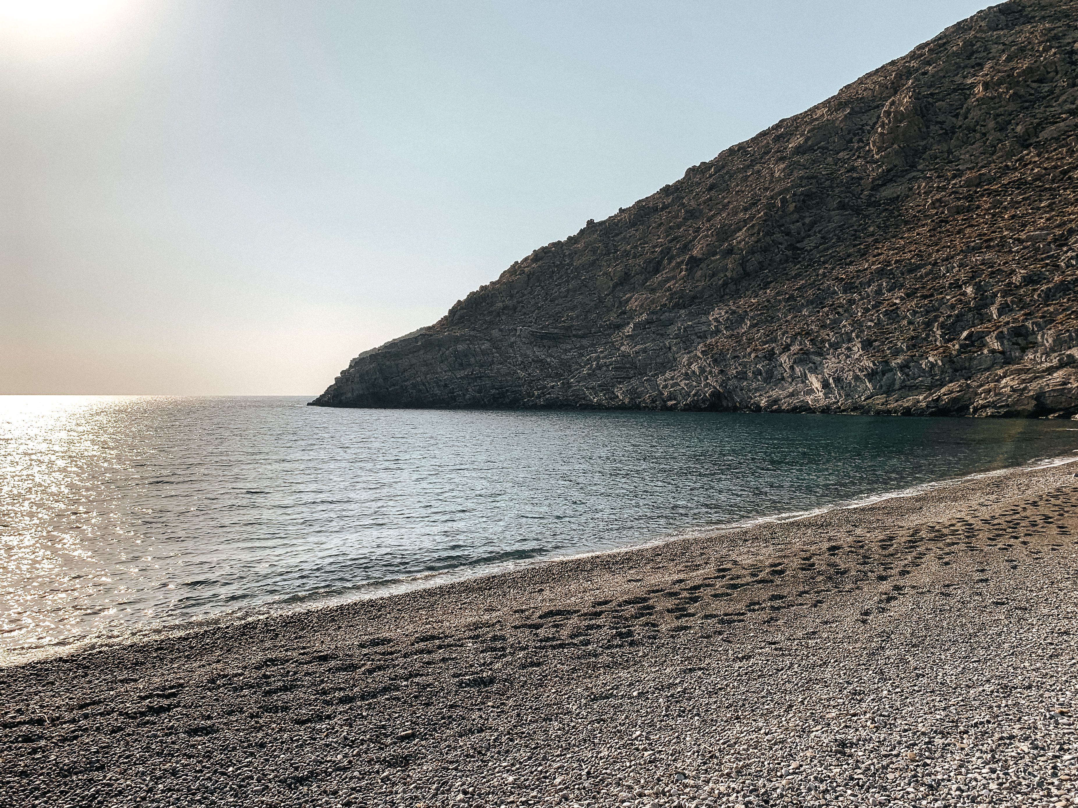 A quiet beach with calm water and rocky slopes at Astypalea.