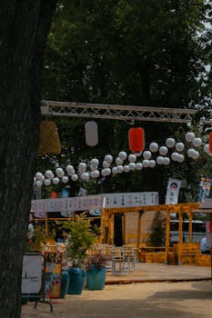 Charming display of Japanese lanterns in a Paris park setting during a summer festival.
