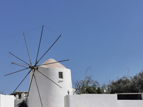 Free Traditional Greek windmill in Parikia, Greece, with clear blue skies, showcasing Cycladic architecture. Stock Photo