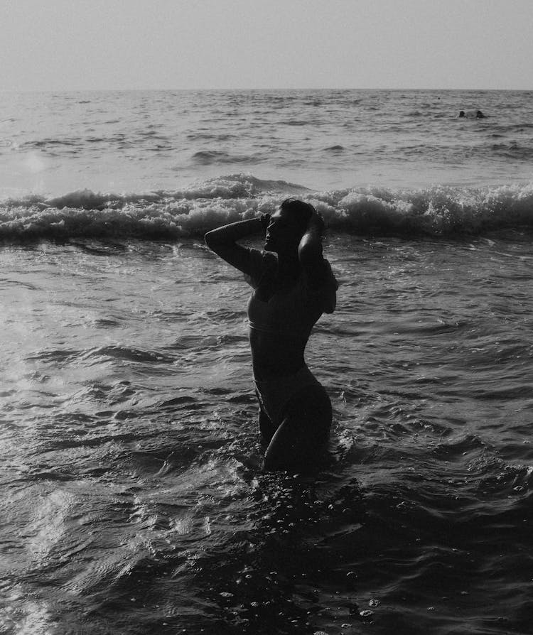 Woman In Black And White In Water On Shore