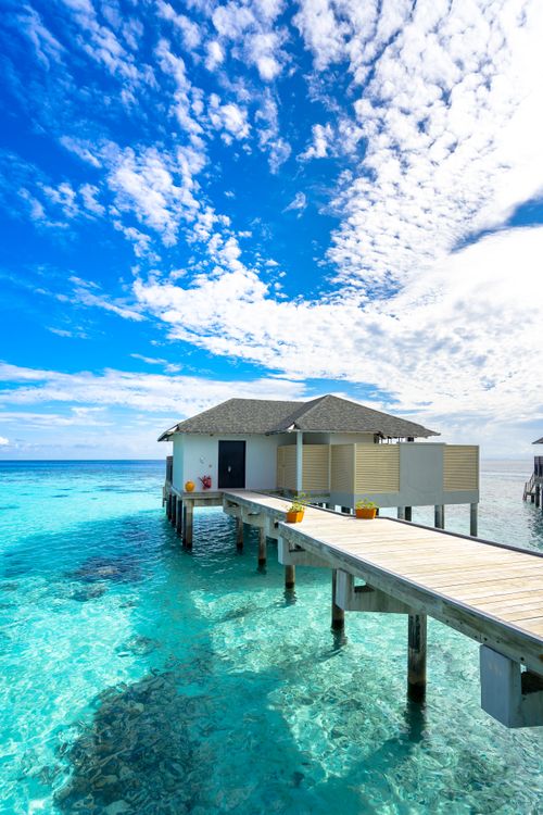 Free Discover tranquil overwater villas amid stunning azure waters and vibrant coral reefs in the Maldives. Stock Photo