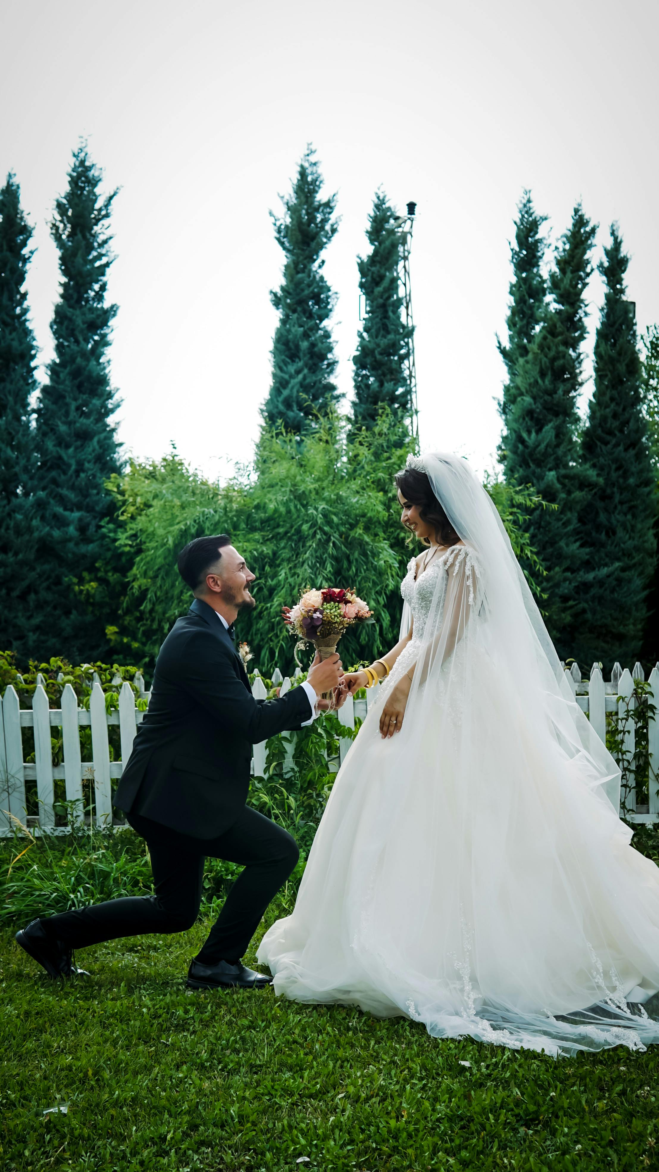 Bride and groom share a romantic moment amidst lush greenery.