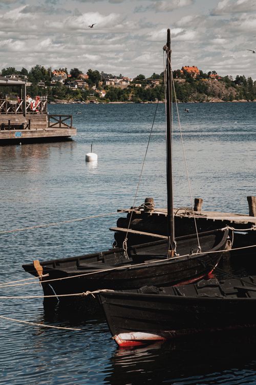 Free Scenic view of traditional wooden boats moored in a Stockholm harbor, capturing a serene maritime scene. Stock Photo