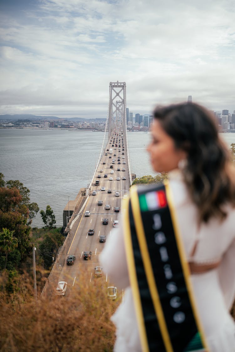 Woman Standing On A Hill Overlooking A Golden Gate Bridge In San Francisco 