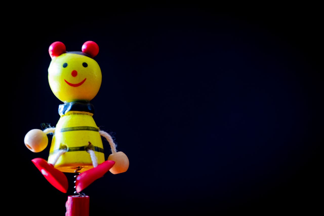 close up of a colorful bee toy on a black background exuding a sense o