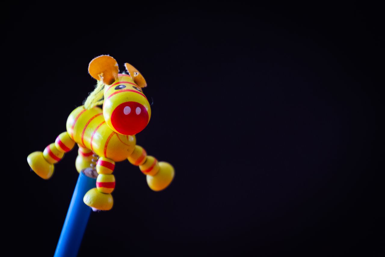 vibrant yellow toy donkey in focus against a dark background capturing