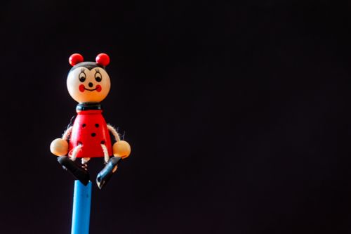Free Charming ladybird toy on a stick against a black background, perfect for playful designs. Stock Photo