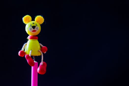 A bright and colorful toy mouse with a black background, ideal for playful themes.