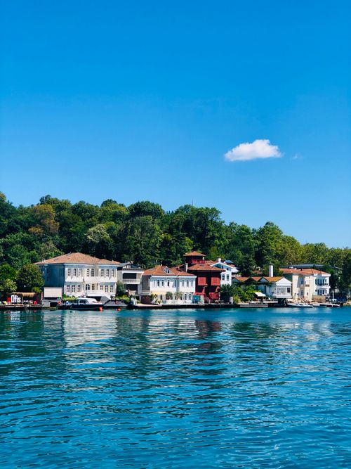 Free Idyllic view of luxurious villas along the coastline with clear skies and calm waters. Stock Photo