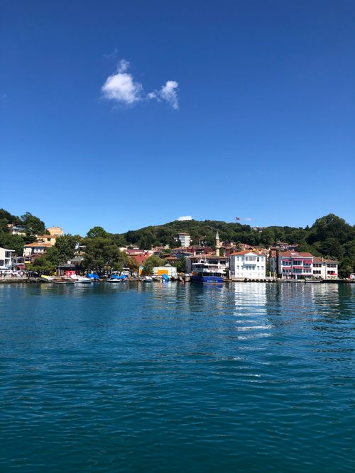 Free Charming waterfront town on a sunny day with bright blue skies and vibrant architecture reflecting on the water. Stock Photo