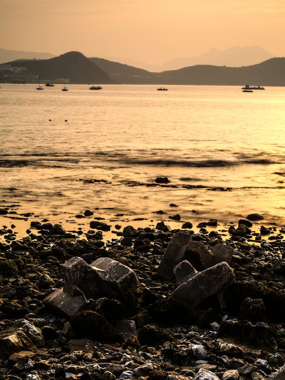 Gray Rocks on the Shore During Sunset