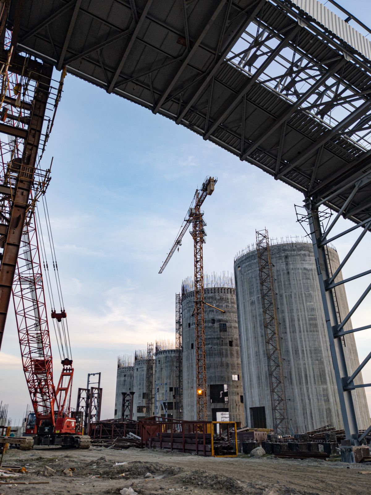 Tower cranes and silos at an industrial construction site in Bangladesh