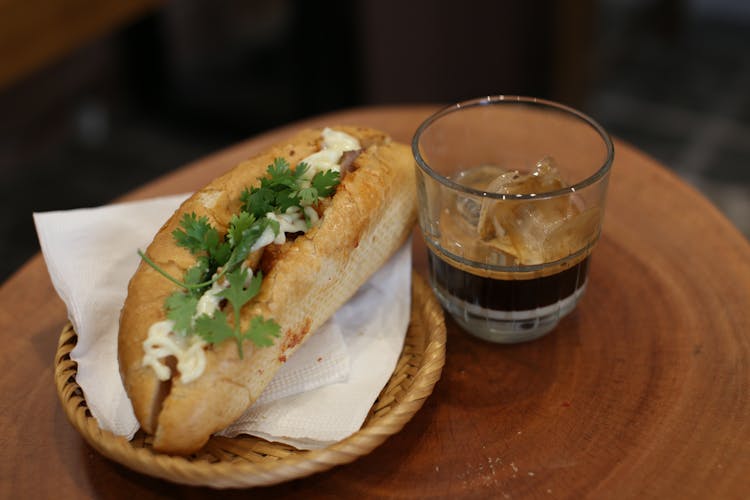 Sandwich And Glass Of Ice Cold Coffee On A Wooden Table