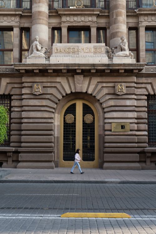 Free Woman walking past the Banco de México, an iconic historic facade in Mexico City. Stock Photo