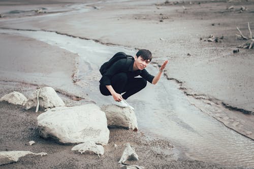 Free Man Carrying Backpack Near River Stock Photo