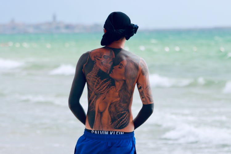 A Shirtless Man With Tattoo On His Back