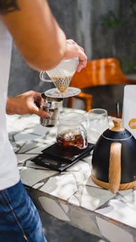 Close-up of a pour over coffee brewing setup with glass objects in a modern kitchen.