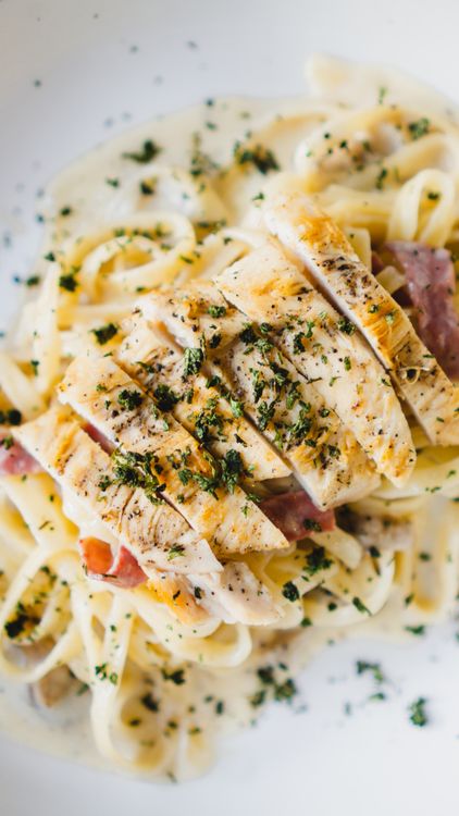 Sliced seasoned chicken served over creamy pasta