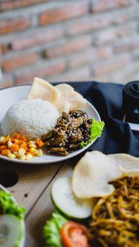 A beautifully presented Asian rice dish with mixed vegetables and garnishes.