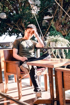 一个年轻人坐在户外，在自然光下沉思